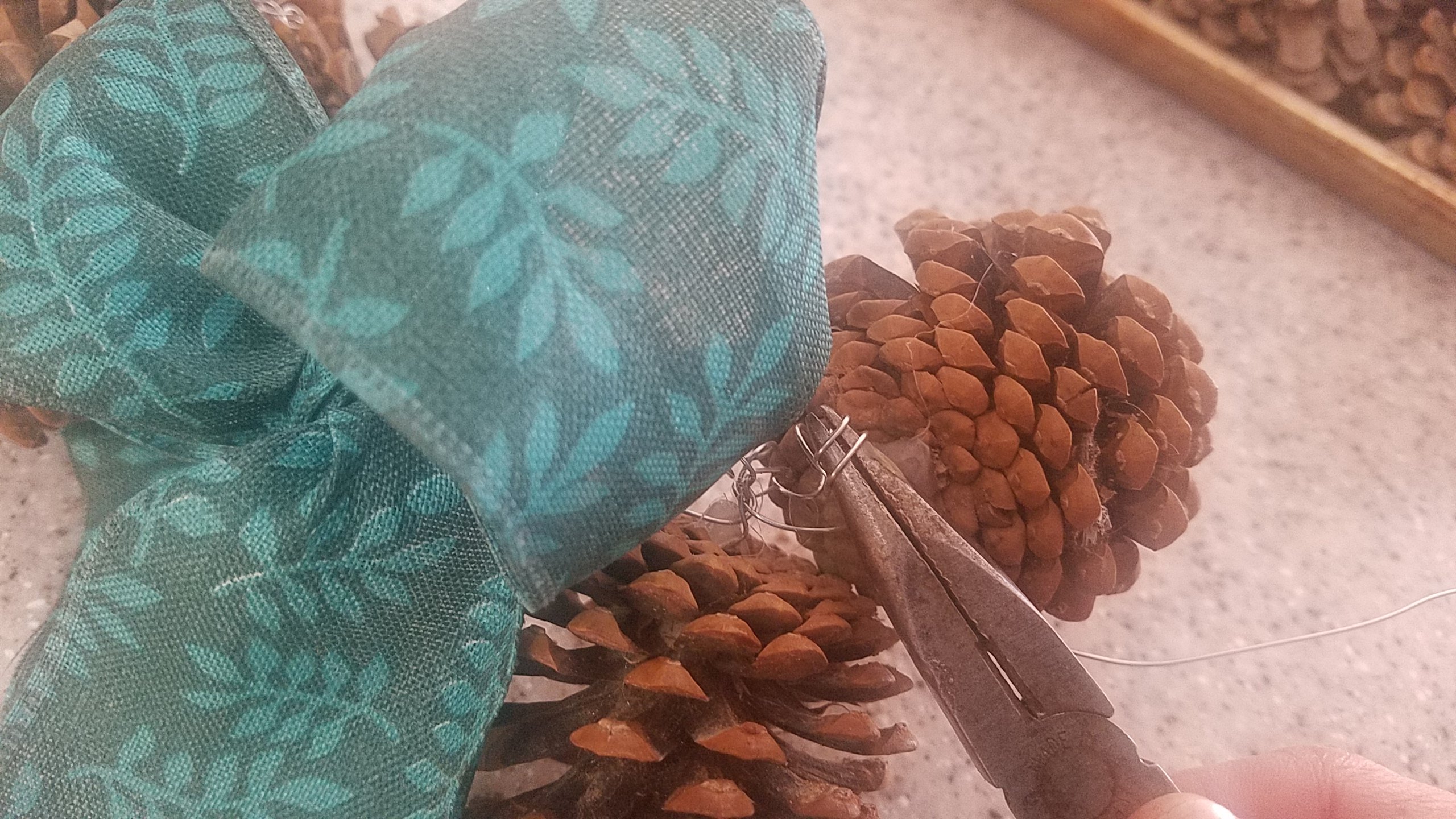 When wire is left sticking out after twisting the cone to the garland stand, use a set of plyers to bend into a curl. 